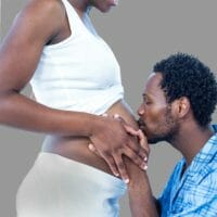 Husband kissing pregnant tummy